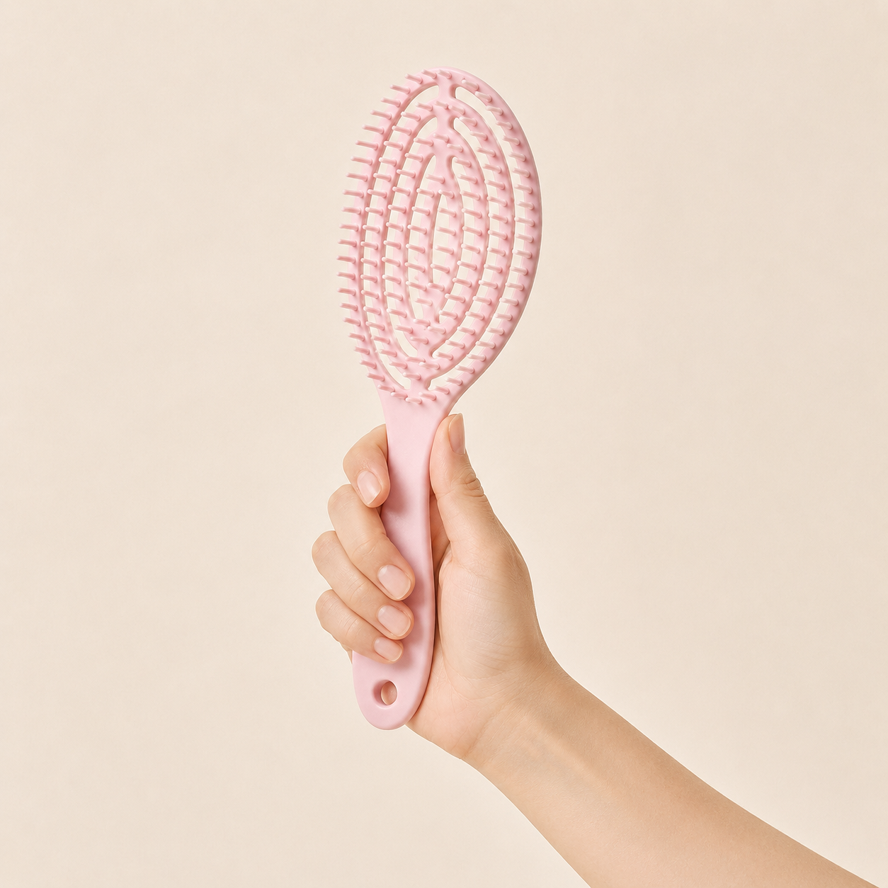 Hand holding the pink Glidura brush by its handle